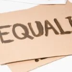 The word Equality painted on a piece of cardboard