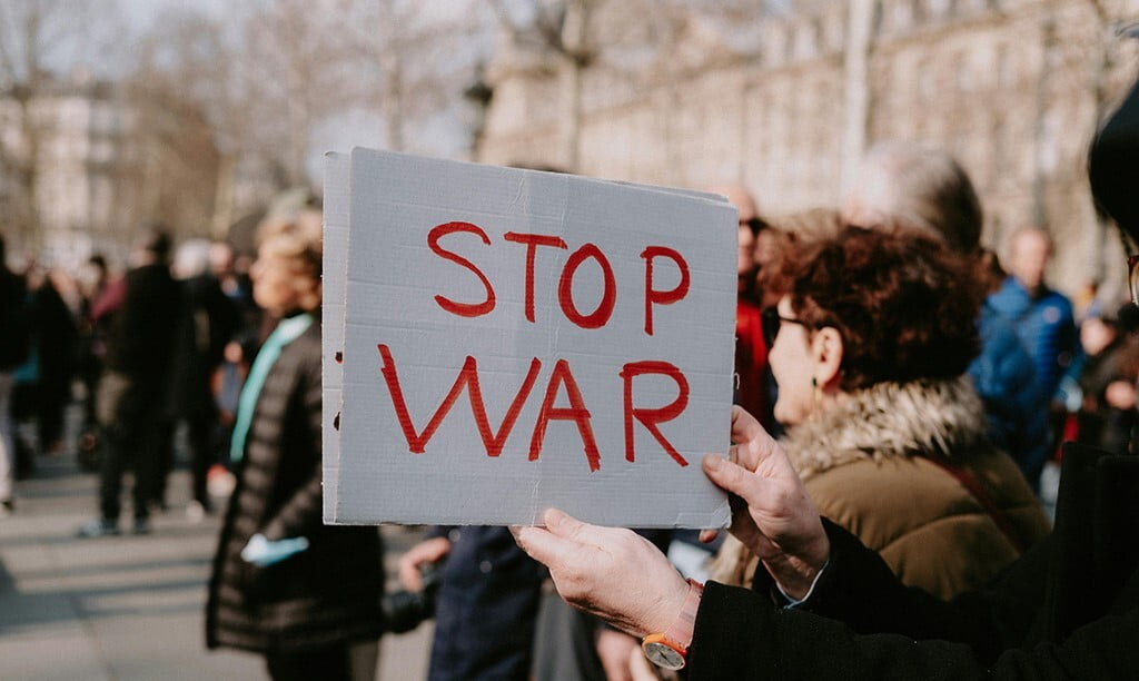 A protestor is holding up a Stop War sign.